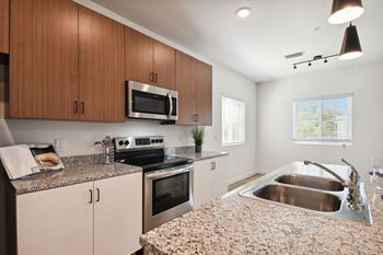 a modern kitchen with granite counter tops and stainless steel appliances